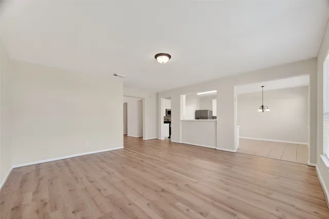a view of an empty room with wooden floor