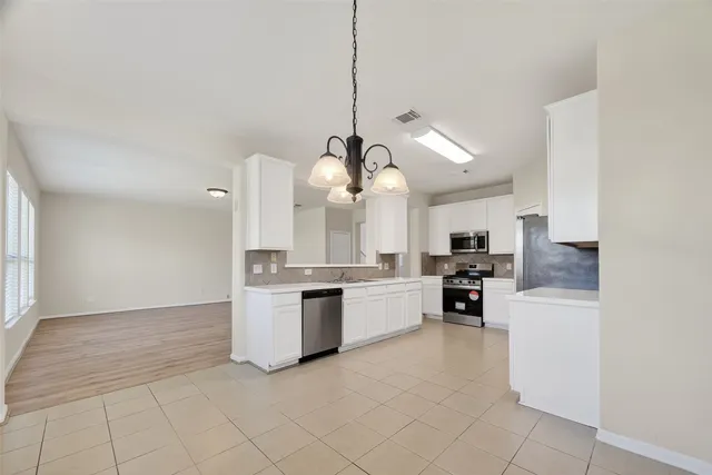 a kitchen with stainless steel appliances kitchen island granite countertop a stove a sink and a refrigerator