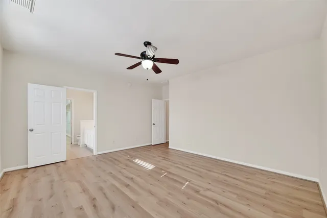 a view of room with wooden floor and ceiling fan