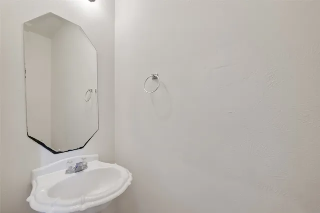 an empty room with a hallway and a ceiling fan