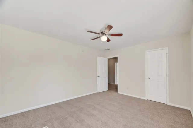 an empty room with a window and a ceiling fan