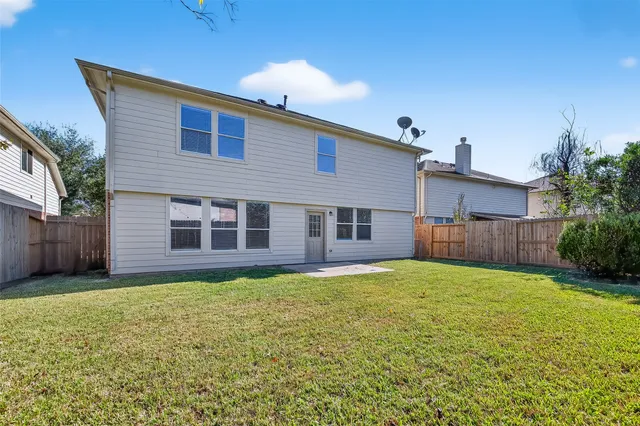 a front view of house with yard and trees in the background