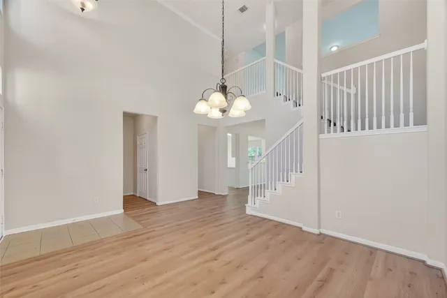 a view of a room with wooden floor white walls and stairs