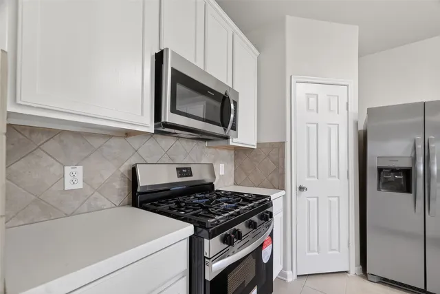 a kitchen with stainless steel appliances a refrigerator stove and microwave