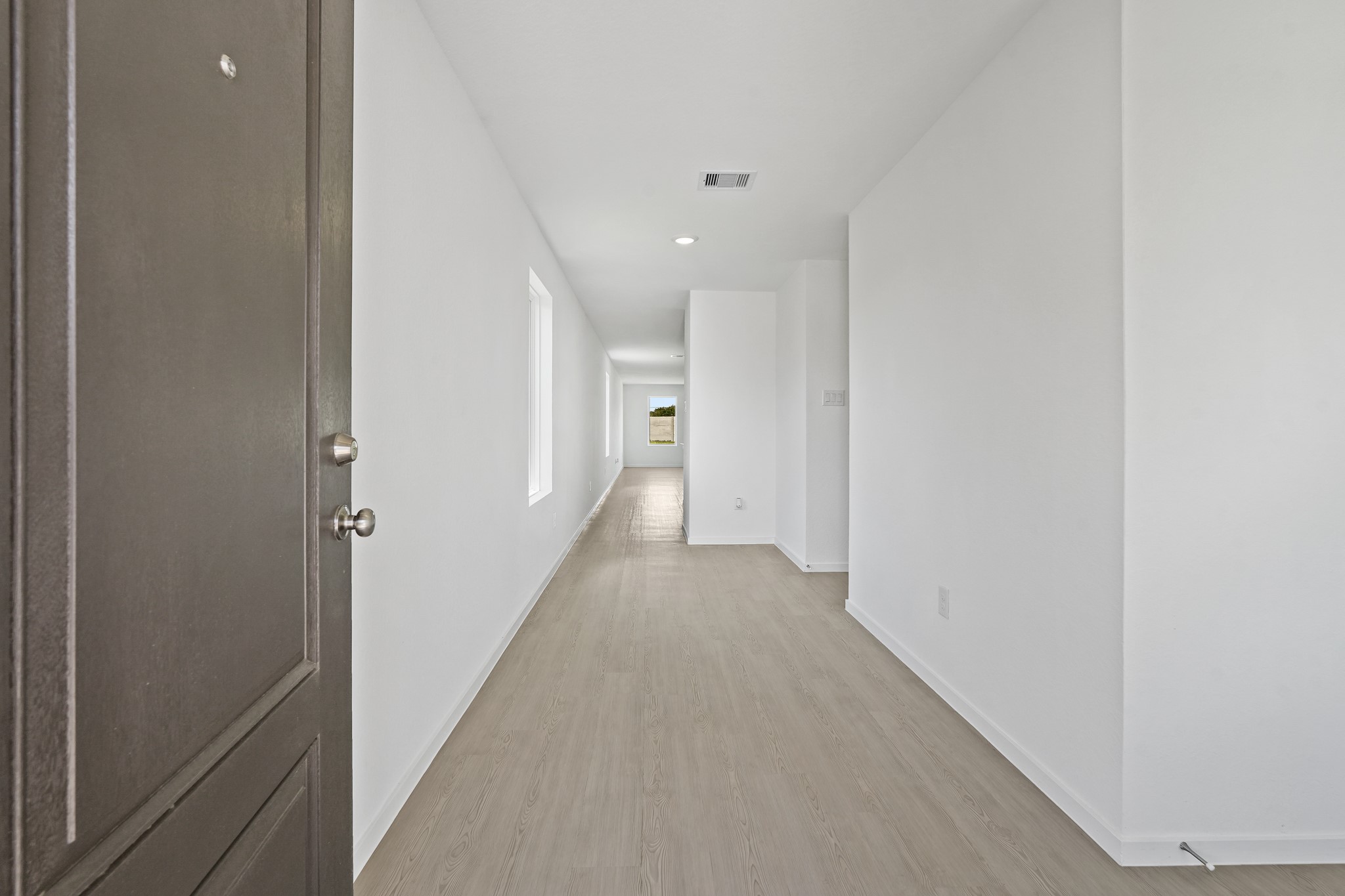 26931 Feather Reed Drive Katy, TX 77493 - Photo 2 of 16 The formal entry foyer features durable vinyl plank flooring and crisp neutral walls, offering a functional and welcoming first impression as you step inside the long transition hallway.