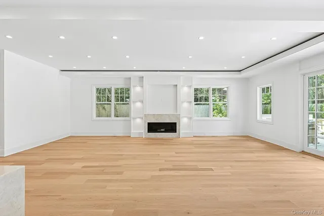 a view of an empty room with a fireplace and a window