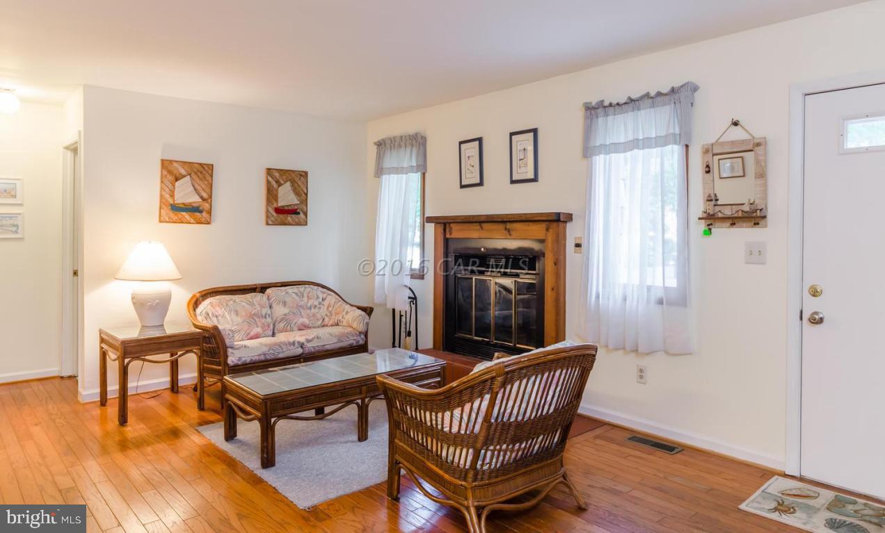 13 Capetown Road Ocean Pines, MD 21811 - Photo 4 of 46 a living room with furniture a fireplace and wooden floor