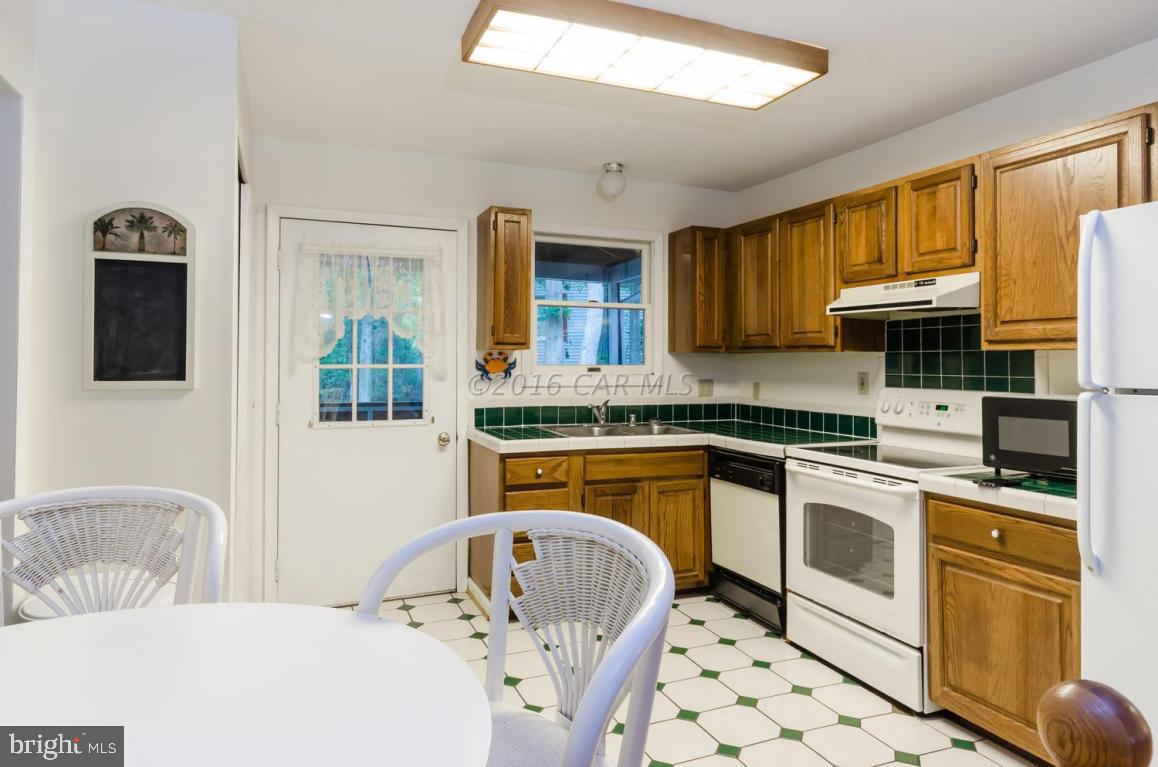 13 Capetown Road Ocean Pines, MD 21811 - Photo 8 of 46 a kitchen with stainless steel appliances granite countertop a sink a stove a microwave cabinets and a dining table