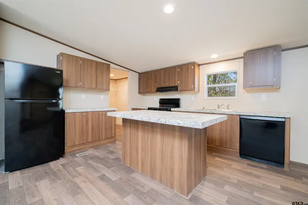 a kitchen with a refrigerator and a stove top oven