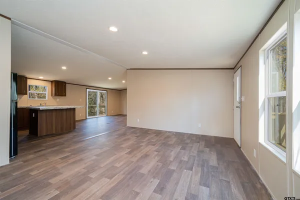 a view of a big room with wooden floor and windows