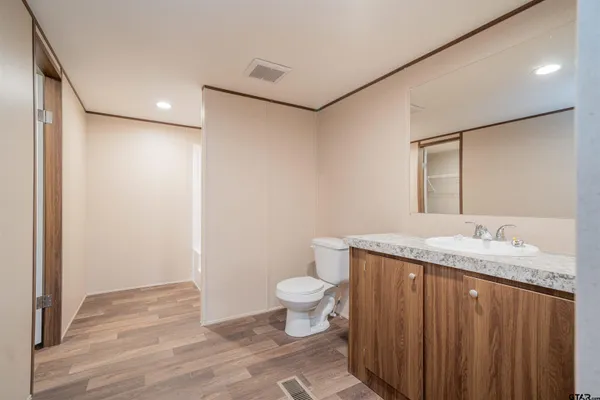 a bathroom with a granite countertop sink a toilet and a mirror