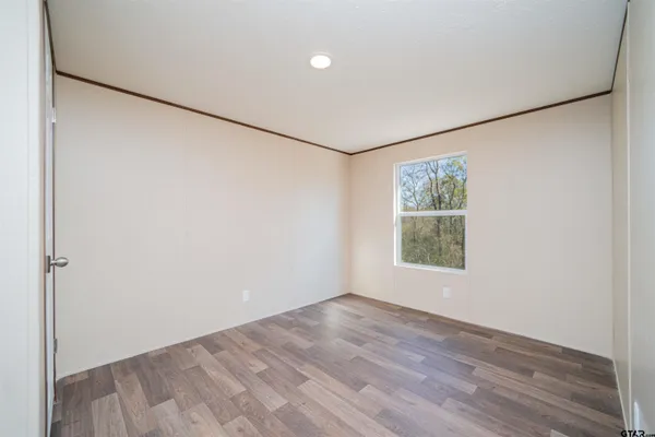 a view of a big room with wooden floor and windows