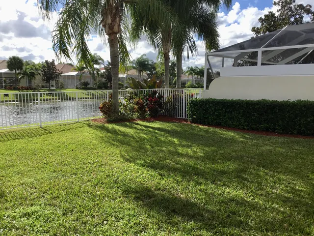 a view of house with swimming pool and green space