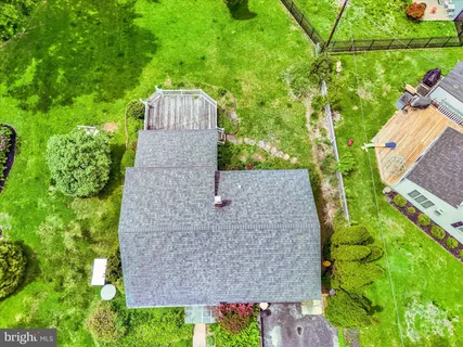 an aerial view of a house with a yard and large trees