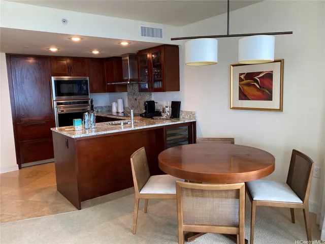 a kitchen with a dining table chairs and a refrigerator