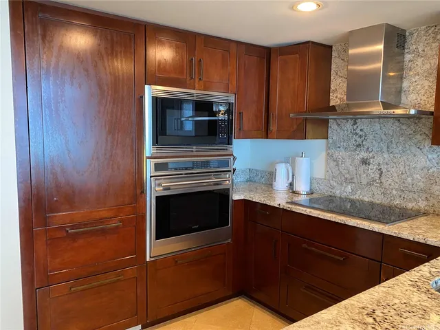a kitchen with granite countertop wooden cabinets and stainless steel appliances