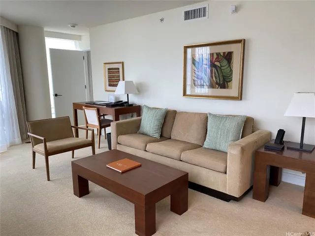 a living room with furniture a lamp paintings and a window