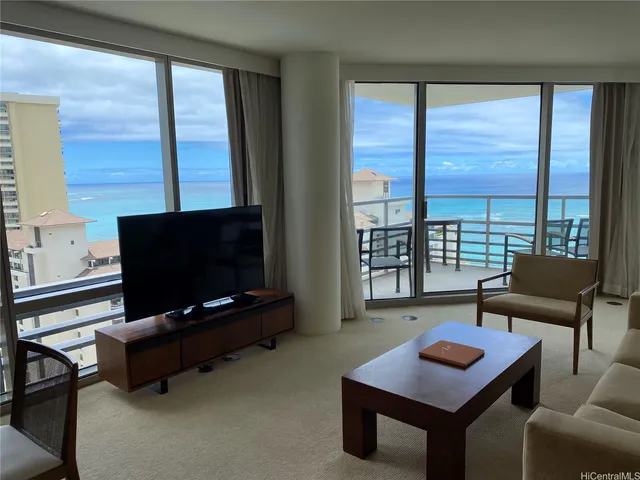 a living room with furniture a flat screen tv and a floor to ceiling window
