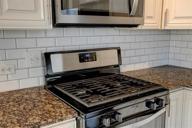 a stove top oven sitting inside of a kitchen