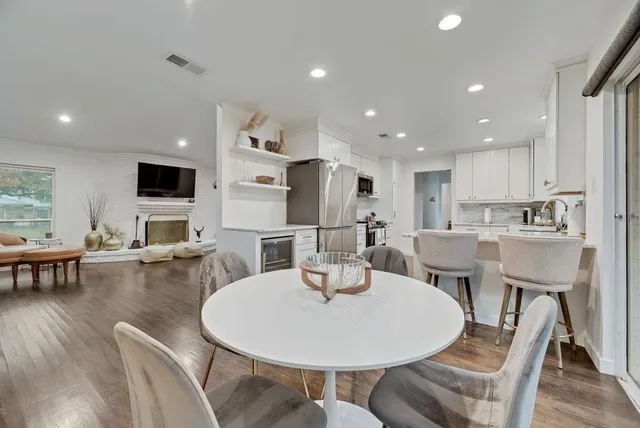 a kitchen with a dining table chairs and refrigerator