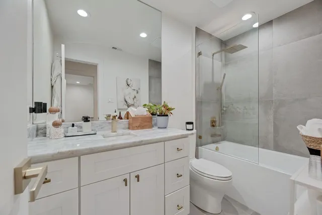 a bathroom with a sink a toilet and shower