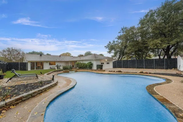 a swimming pool with outdoor seating and yard