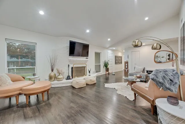 a living room with furniture a fireplace and a flat screen tv
