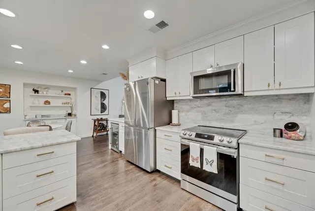 a kitchen with stainless steel appliances a stove microwave and refrigerator