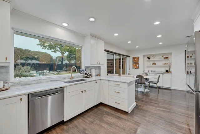 a large white kitchen with a large window