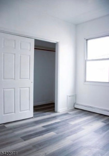 5 Timothy Street, Unit 4 Paterson, NJ 07503 - Photo 5 of 16 an empty room with wooden floor and windows