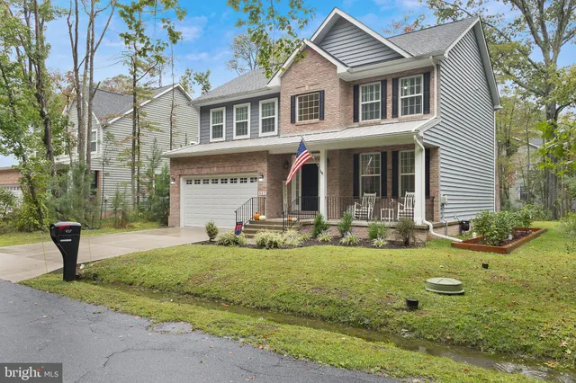 a view of a white house with a yard and plants