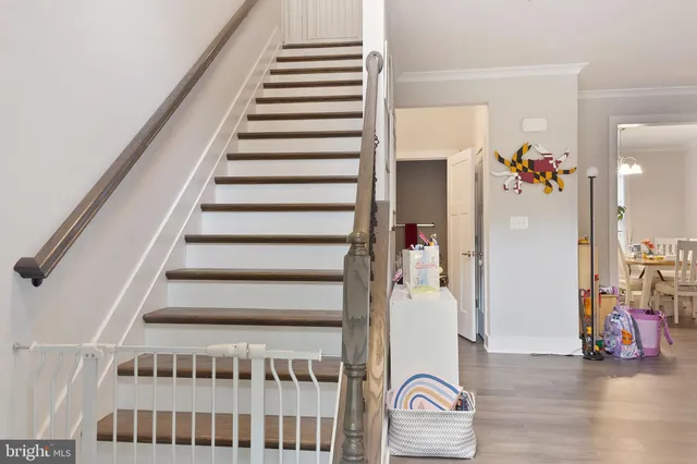 a view of staircase with white walls and wooden floor