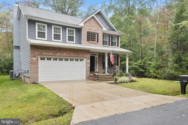 a view of house with backyard and glass windows
