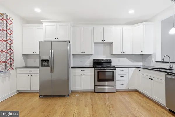 a kitchen with stainless steel appliances a refrigerator sink and cabinets
