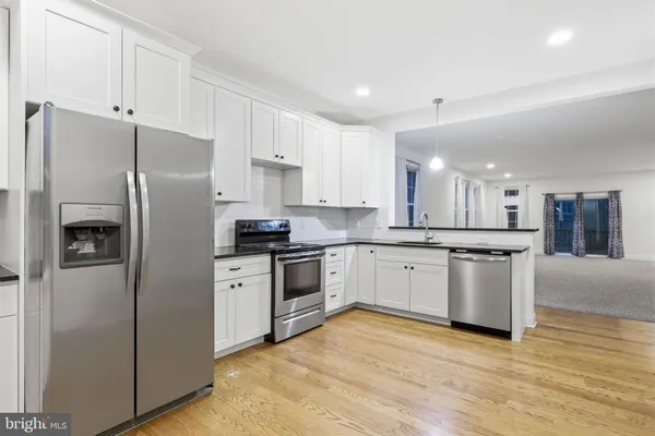a kitchen with stainless steel appliances granite countertop a refrigerator sink and stove