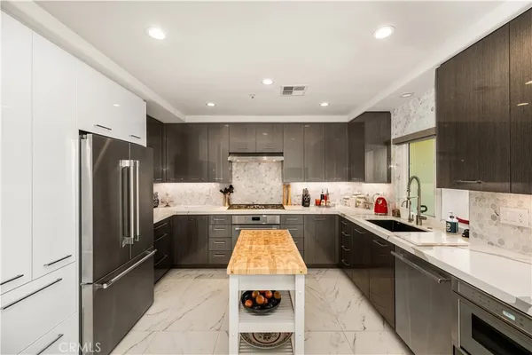 a kitchen with stainless steel appliances granite countertop a sink stove and refrigerator