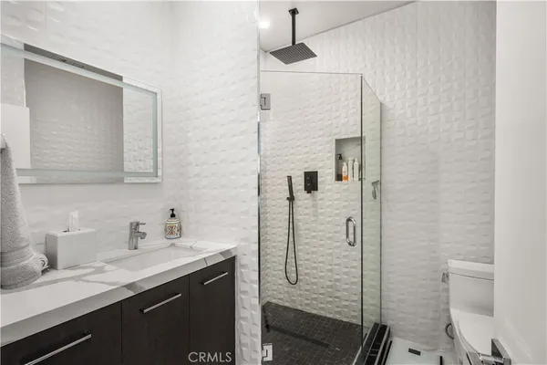 a bathroom with a sink a toilet and shower