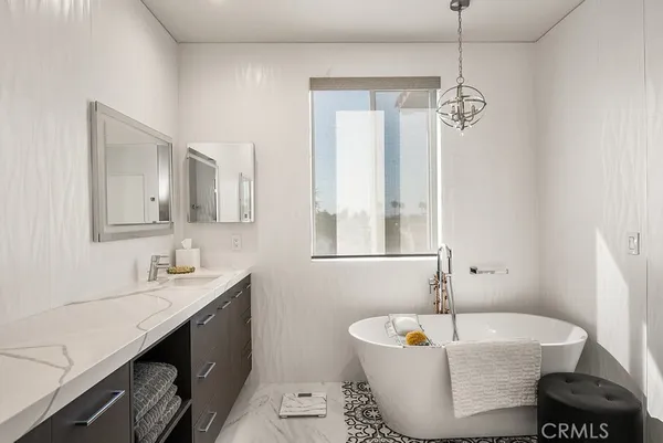 a spacious bathroom with a tub sink and mirror