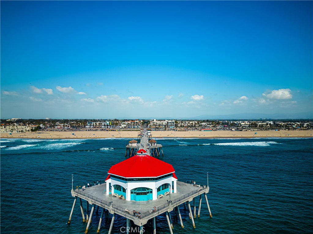 340 5th Street Huntington Beach, CA 92648 - Photo 43 of 48 a view of a balcony with table and chairs under an umbrella next to a lake