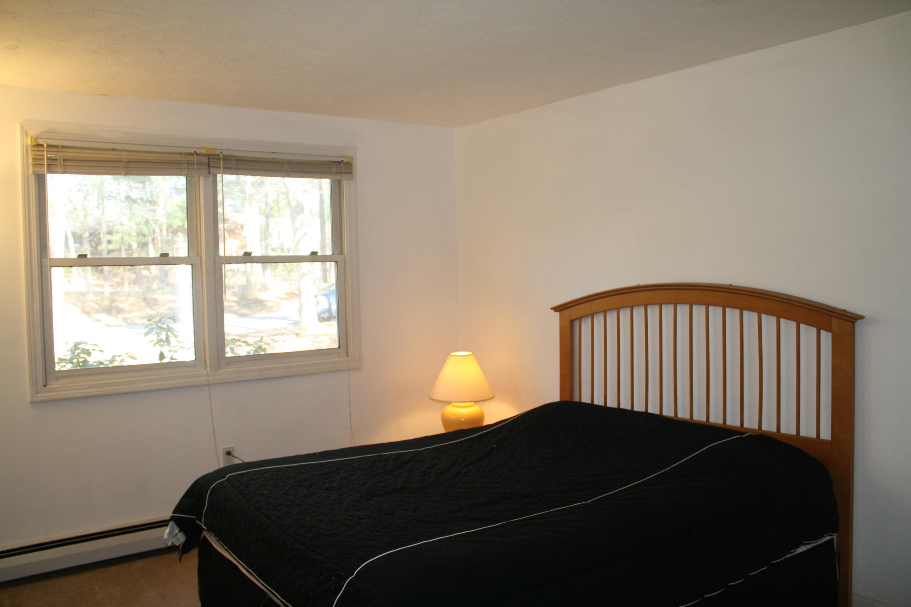 207 Simon Narrows Road Mashpee, MA 02649 - Photo 9 of 18 a bedroom with a lamp and window