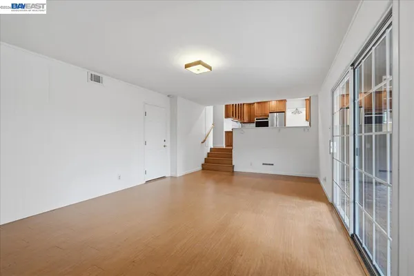 a view of a hallway with wooden floor and chandelier