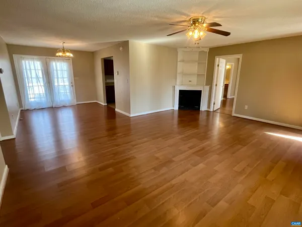 a view of a livingroom with a fireplace wooden floor and a window