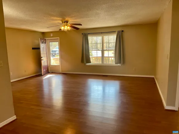 a view of a livingroom with wooden floor and a ceiling fan