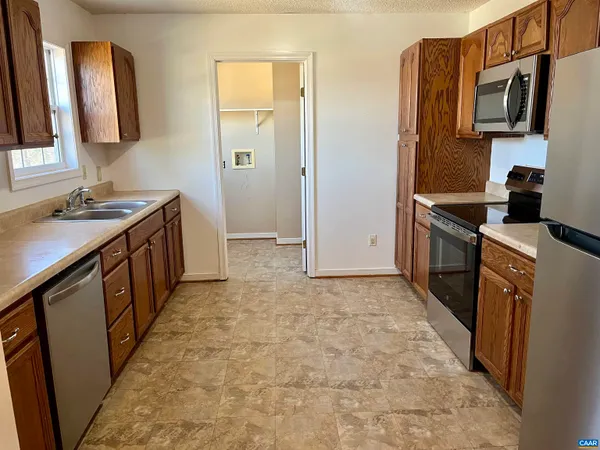 a kitchen with stainless steel appliances granite countertop a refrigerator and a stove top oven