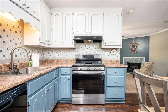 a kitchen with granite countertop a sink stove and cabinets