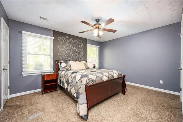 a bed sitting in a bedroom next to a window