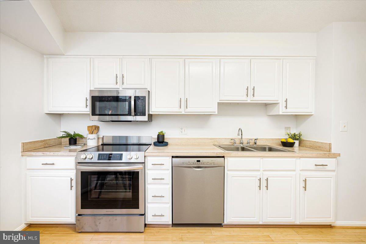 14805 Pennfield Circle, Unit 201 Silver Spring, MD 20906 - Photo 11 of 47 a kitchen with stainless steel appliances granite countertop a stove a sink and a microwave