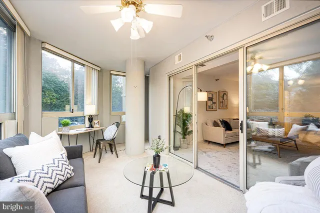a living room with patio furniture and a large window