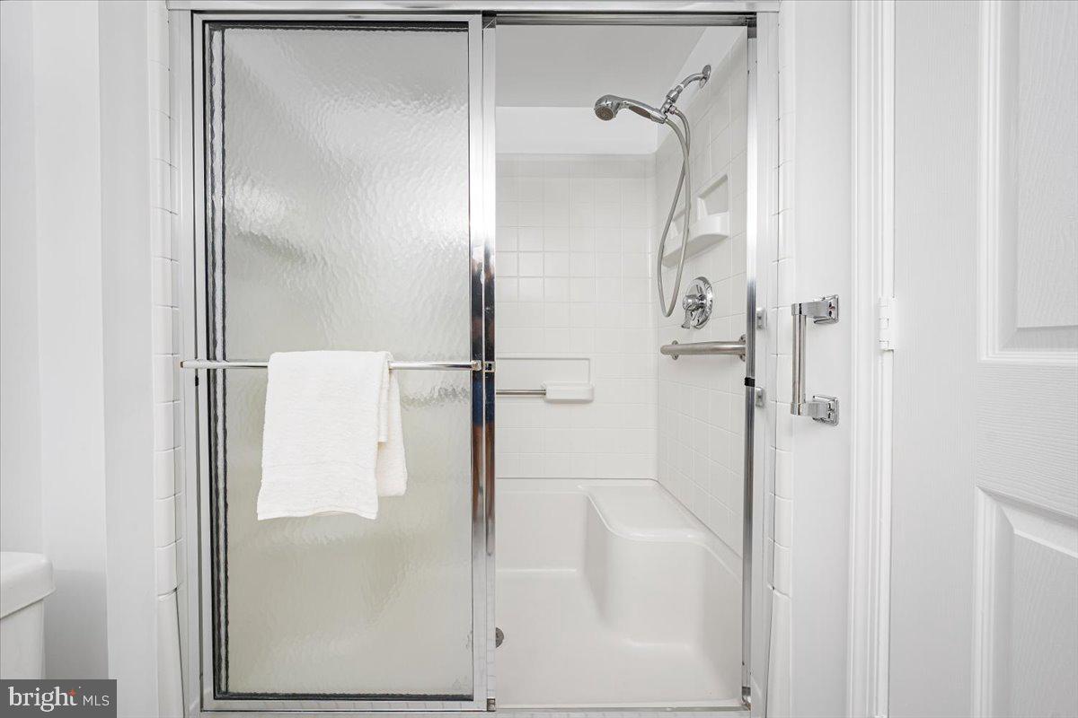 14805 Pennfield Circle, Unit 201 Silver Spring, MD 20906 - Photo 21 of 47 a bathroom with a glass shower door