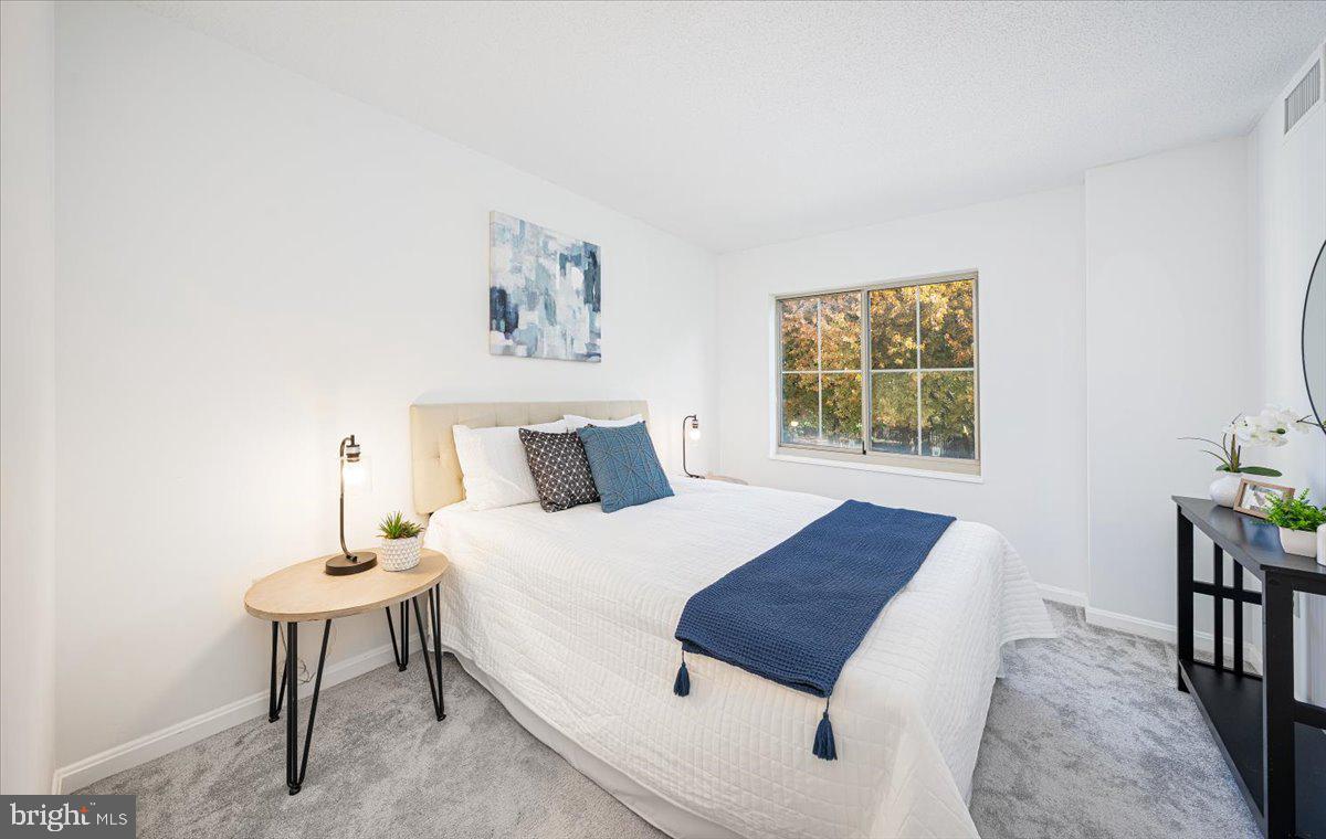 14805 Pennfield Circle, Unit 201 Silver Spring, MD 20906 - Photo 28 of 47 a bedroom with a bed and a table